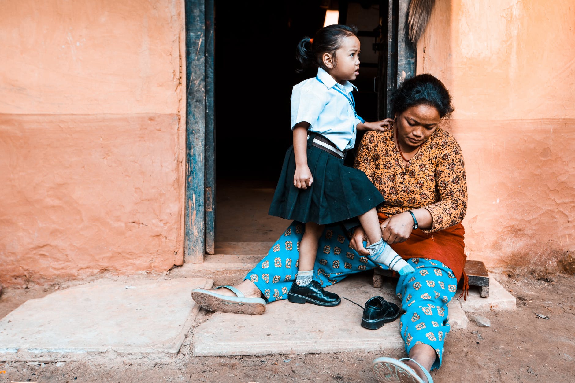 a woman helping her daughter get ready for school