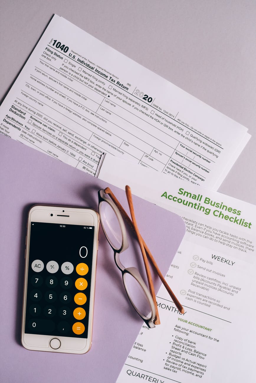 a mobile phone and eyeglasses near the documents on the table